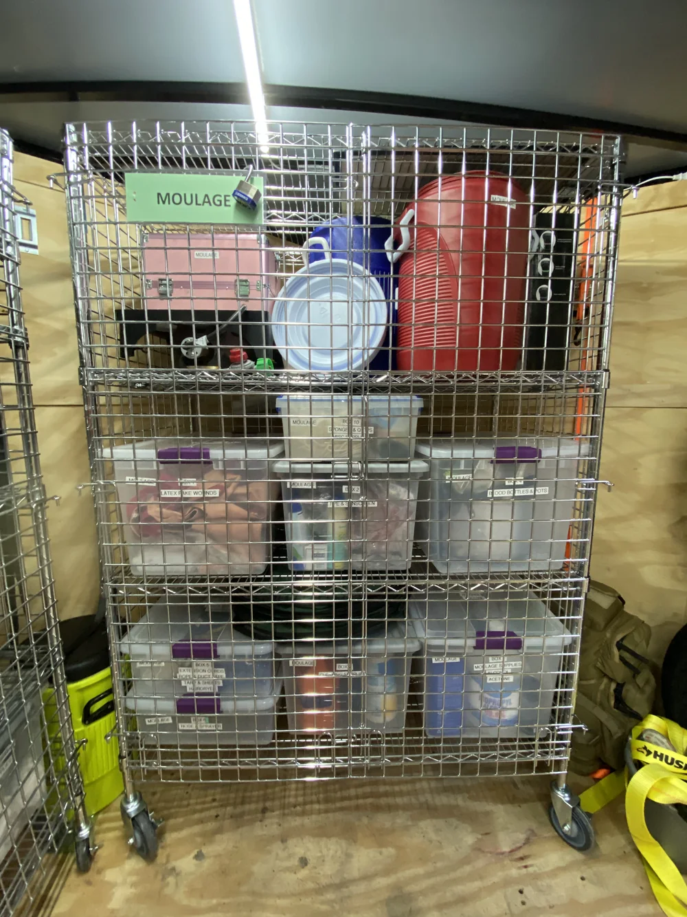 A wire storage cage labelled MOULAGE holding labelled bins of simulated wound supplies.